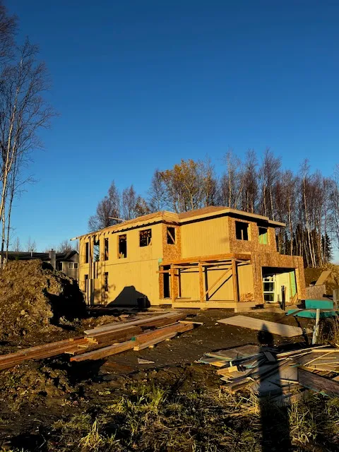 Two-story new home frame at golden hour with mountain views